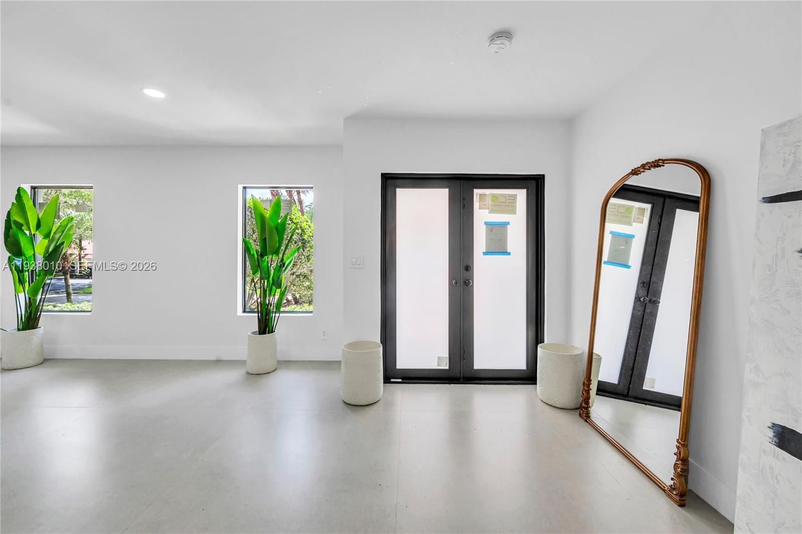 13407 Southwest 59th Avenue Pinecrest, FL 33156 - Photo 5 of 50 an empty room with windows and stairs