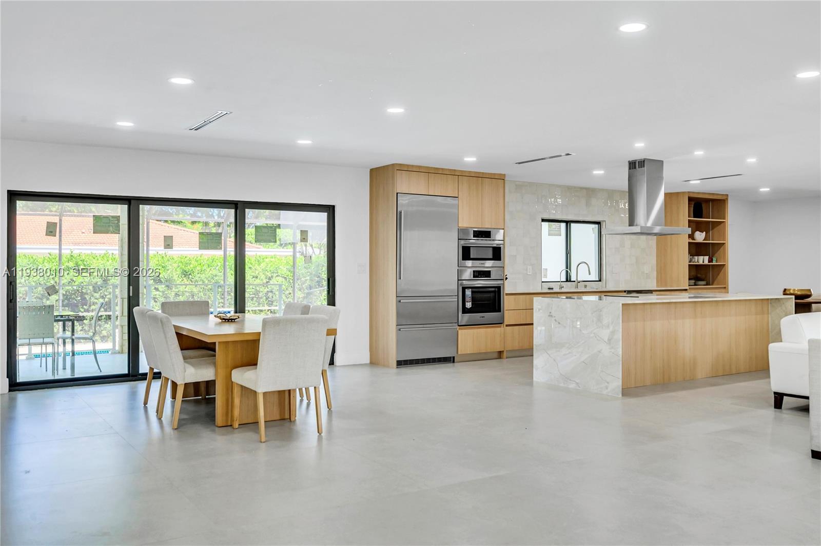 13407 Southwest 59th Avenue Pinecrest, FL 33156 - Photo 8 of 50 a dining hall with stainless steel appliances a dining table wooden floor and a large window