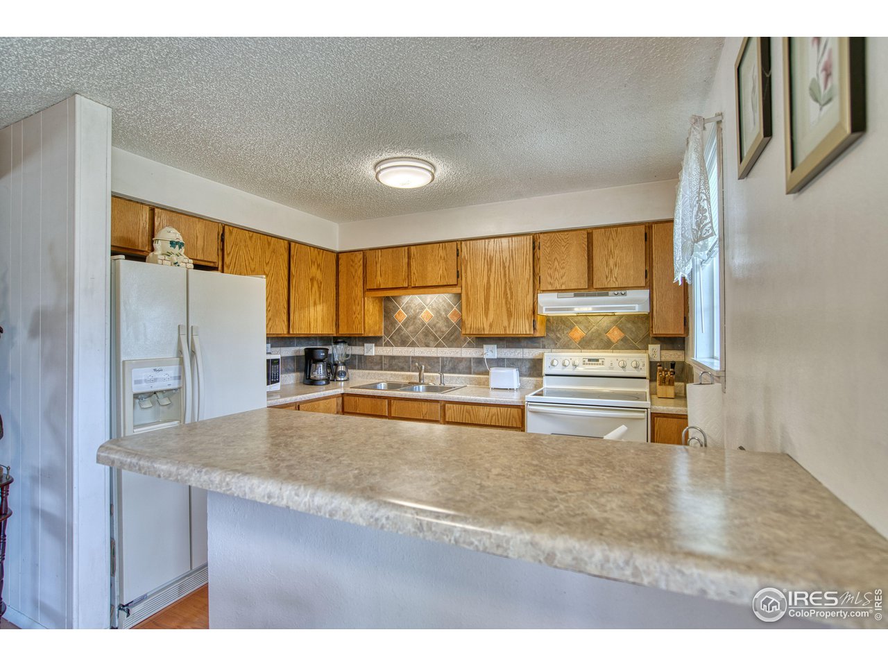 725 Bruce Drive Berthoud, CO 80513 - Photo 9 of 21 a kitchen with stainless steel appliances kitchen island granite countertop a refrigerator a stove and a sink with granite countertops
