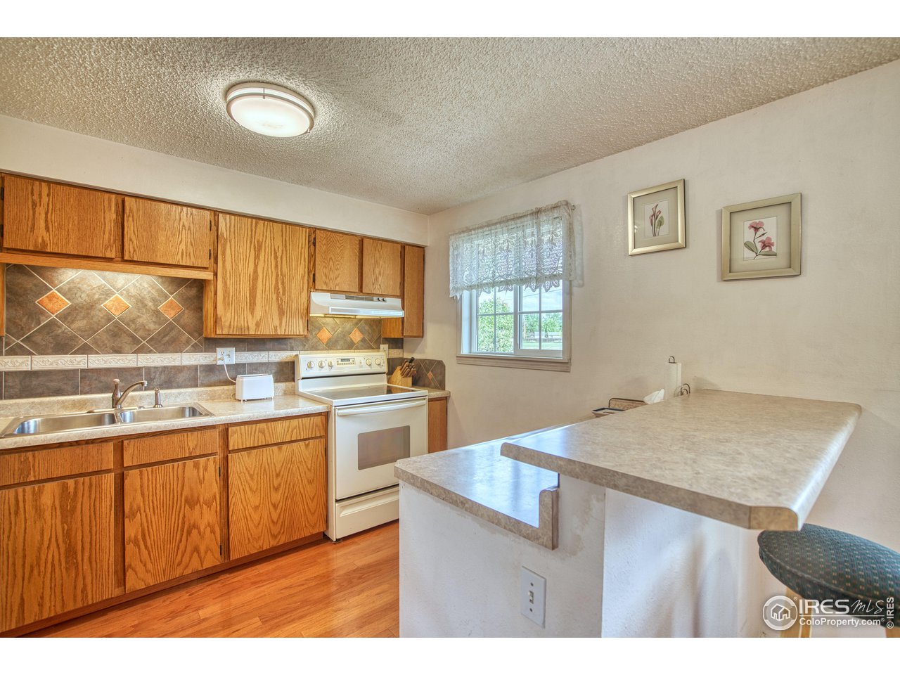 725 Bruce Drive Berthoud, CO 80513 - Photo 10 of 21 a kitchen with a sink cabinets appliances and a window