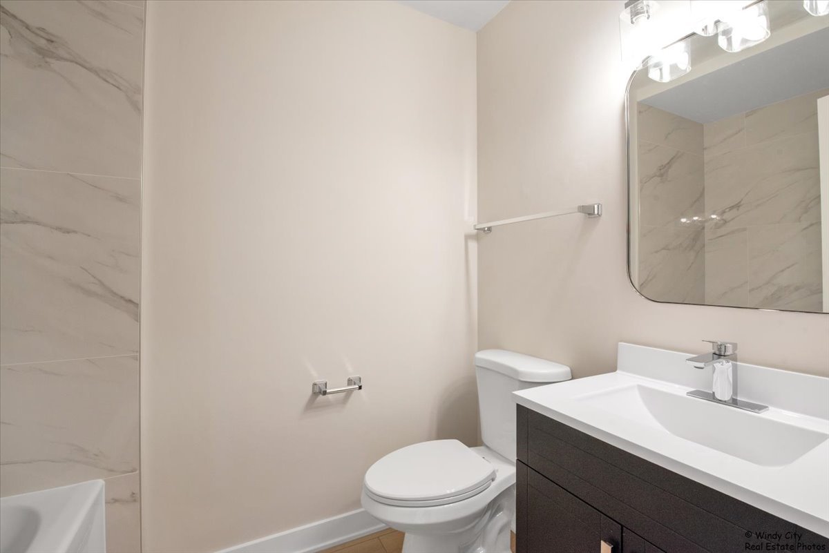 14914 Avers Avenue Midlothian, IL 60445 - Photo 18 of 22 a bathroom with a sink a toilet and a mirror
