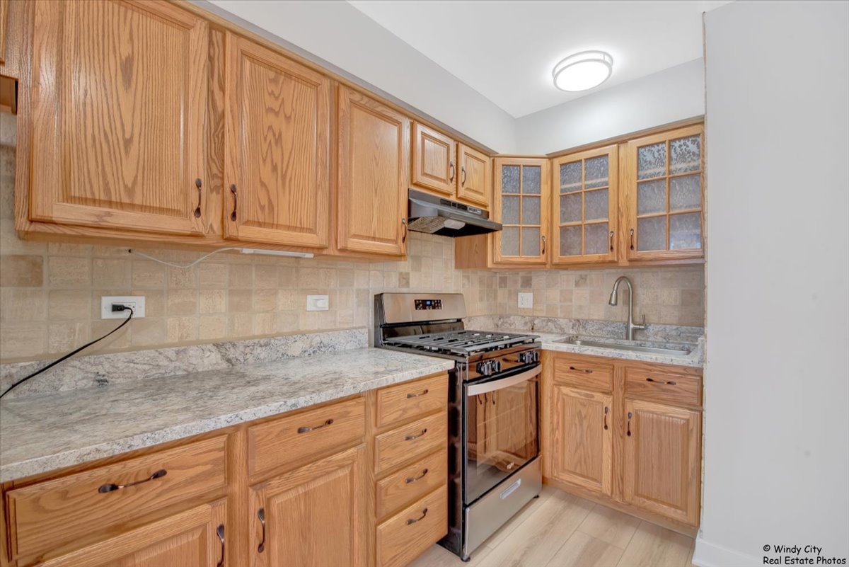 14914 Avers Avenue Midlothian, IL 60445 - Photo 4 of 22 a kitchen with stainless steel appliances granite countertop a sink and cabinets with wooden floor
