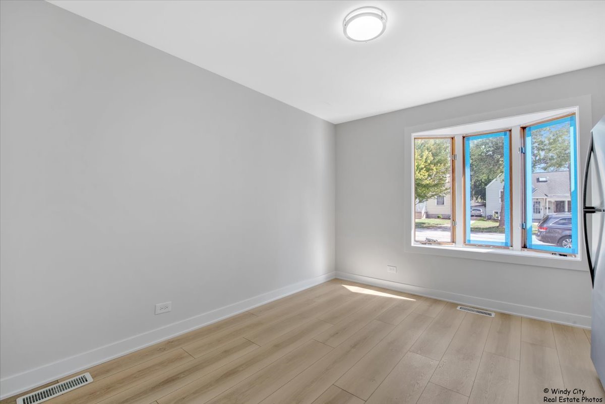 14914 Avers Avenue Midlothian, IL 60445 - Photo 6 of 22 an empty room with wooden floor and windows