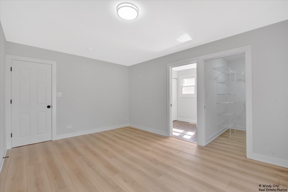 14914 Avers Avenue Midlothian, IL 60445 - Photo 10 of 22 an empty room with wooden floor and windows