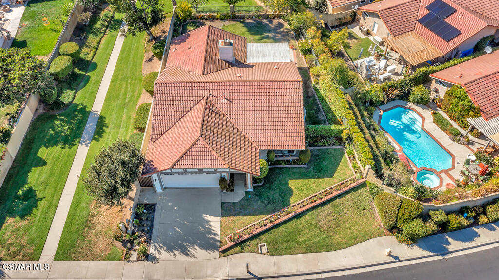 an aerial view of a house with a garden and swimming pool