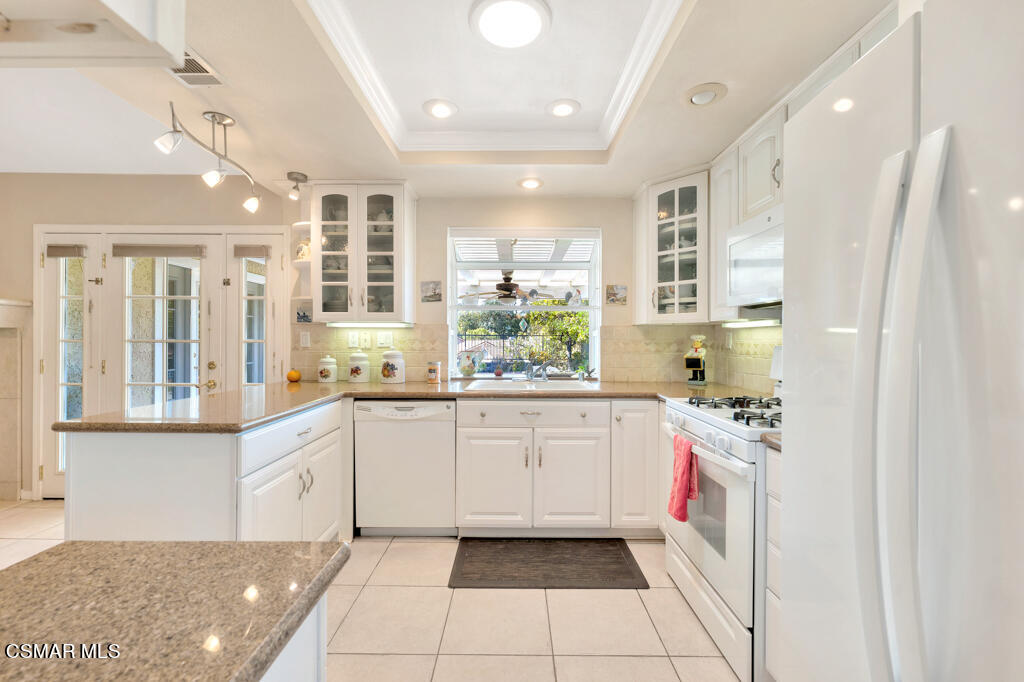 4331 Mill Valley Road Moorpark, CA 93021 - Photo 11 of 40 a large white kitchen with stainless steel appliances granite countertop a sink and cabinets