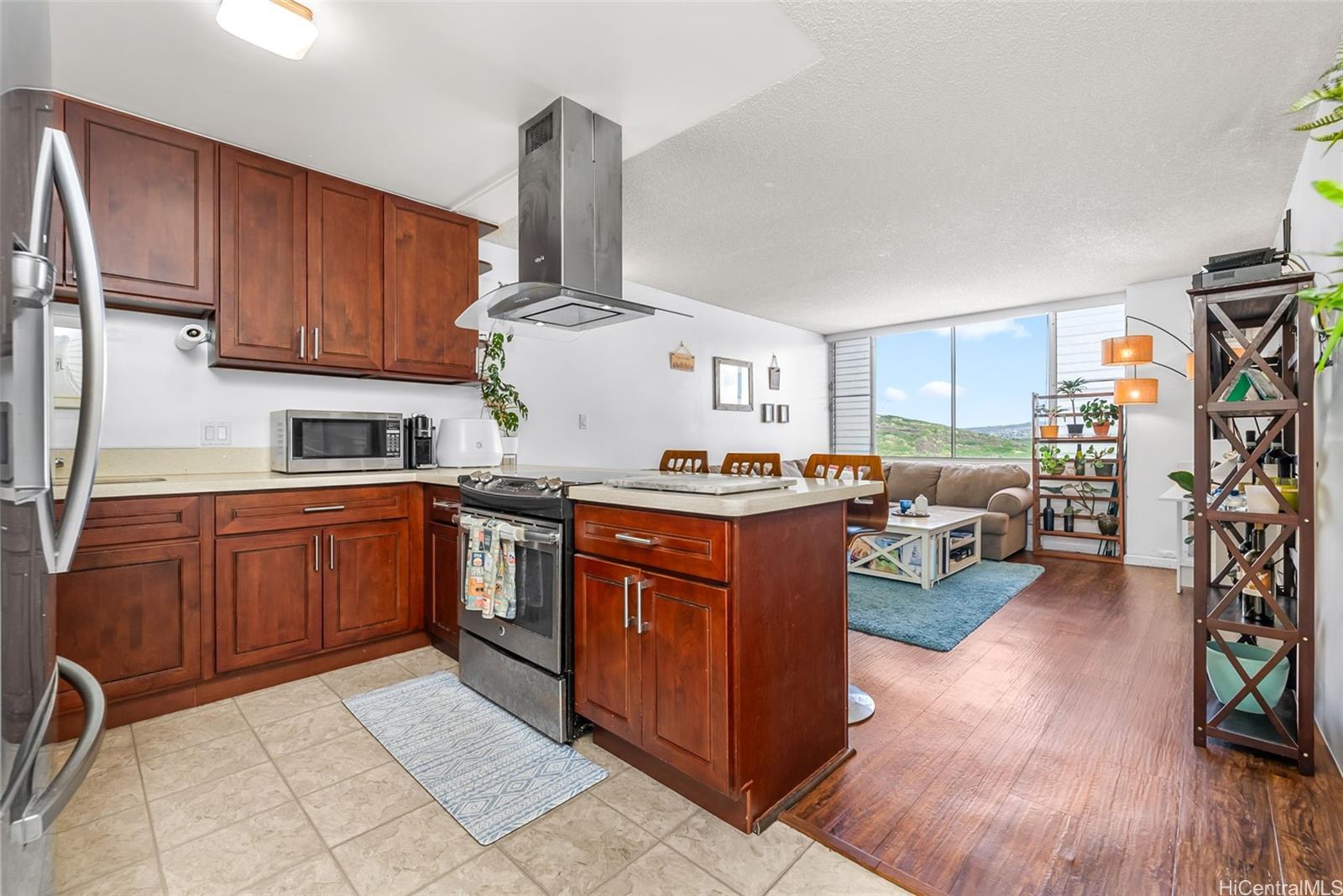 3045 Ala Napuaa Place, Unit 1305 Honolulu, HI 96818 - Photo 4 of 18 a kitchen with stainless steel appliances granite countertop a sink dishwasher stove and refrigerator with wooden floor