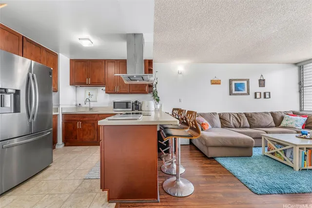 a living room with furniture a refrigerator and kitchen view