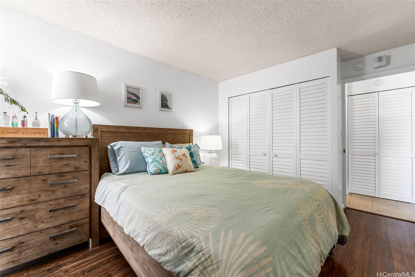 3045 Ala Napuaa Place, Unit 1305 Honolulu, HI 96818 - Photo 9 of 18 a bedroom with a bed and a night stand