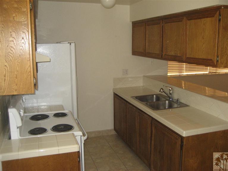 72710 Eagle Road, Unit 4 Palm Desert, CA 92260 - Photo 3 of 9 a kitchen with a sink a stove and cabinets