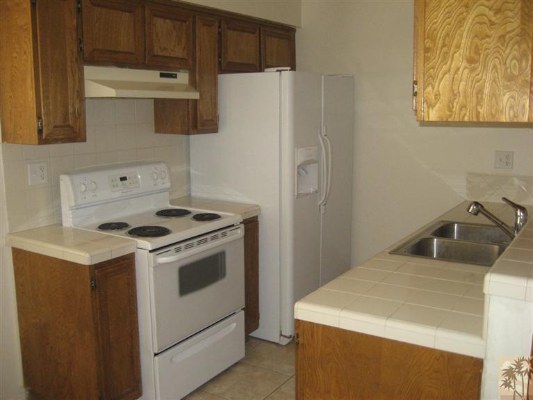 72710 Eagle Road, Unit 4 Palm Desert, CA 92260 - Photo 5 of 9 a kitchen with a stove and a refrigerator