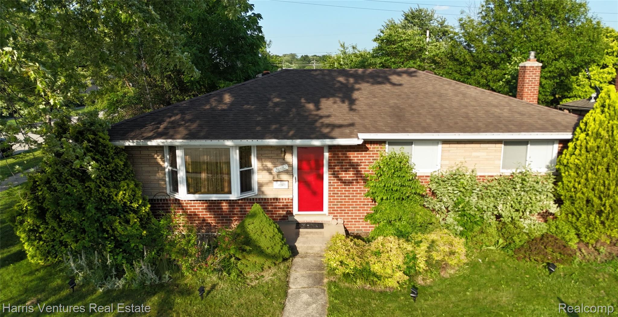 28482 Sutherland Avenue Warren, MI 48088 - Photo 1 of 25 Brick facade residence featuring a prominent red entry door, a bay window, and a shingle roof