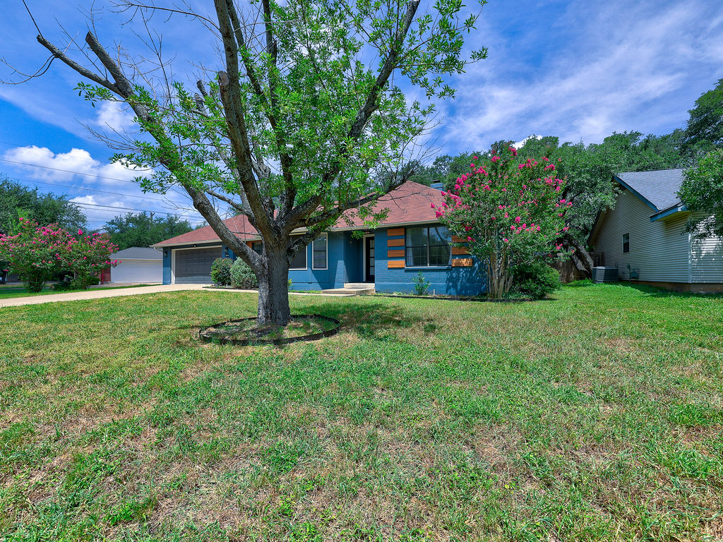 5842 Secrest Drive Austin, TX 78759 - Photo 8 of 40 A well-maintained lawn and mature landscaping enhance this charming single-story residence.
