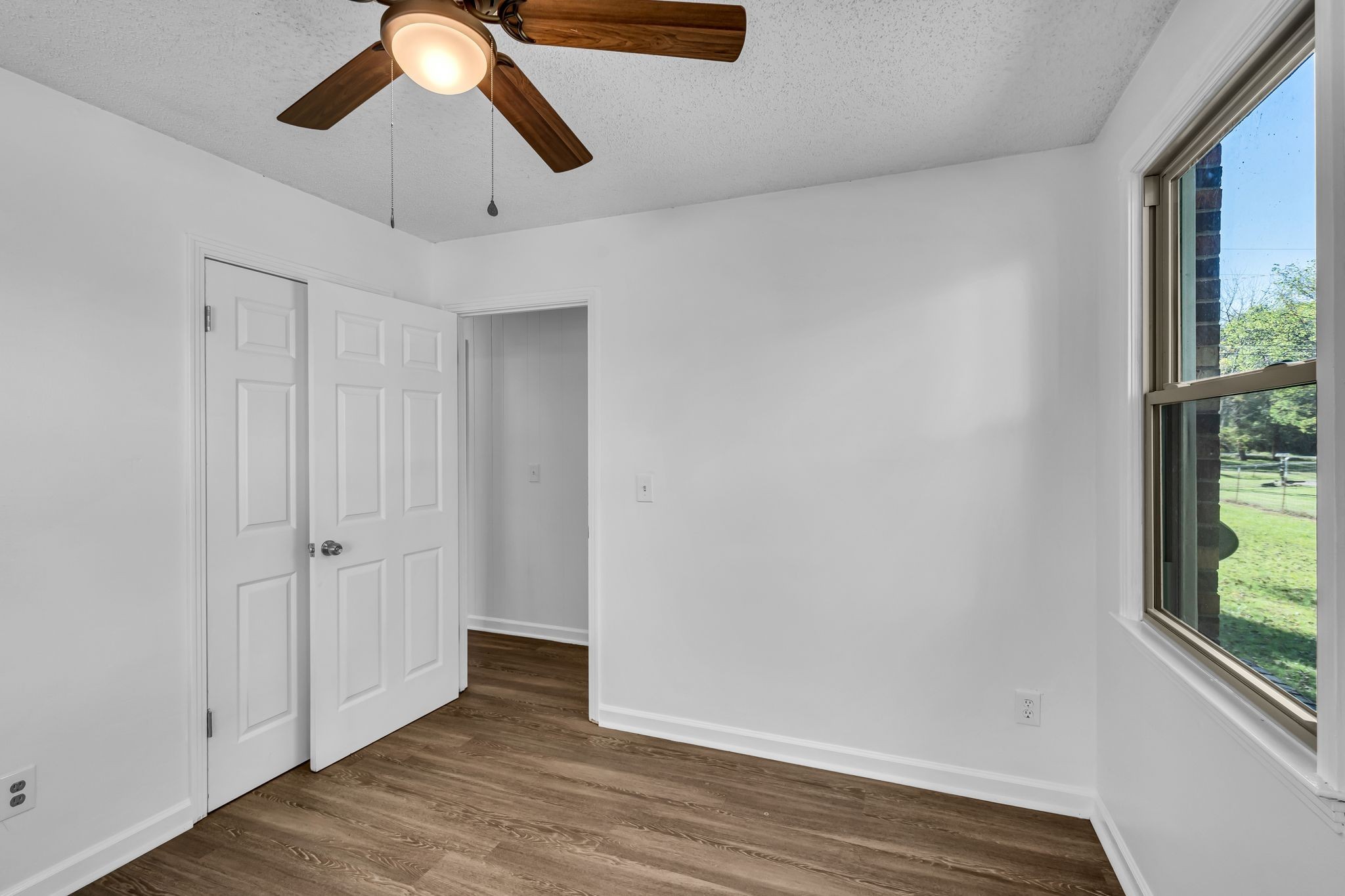 955 Hamilton Chambers Road Lebanon, TN 37087 - Photo 17 of 30 an empty room with wooden floor chandelier fan and windows