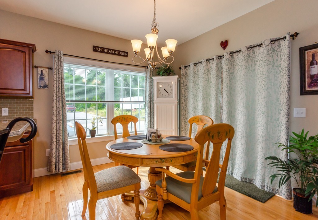 2 Thorn Hill Road, Unit 2 Hooksett, NH 03106 - Photo 12 of 27 a dining room with furniture a chandelier and wooden floor