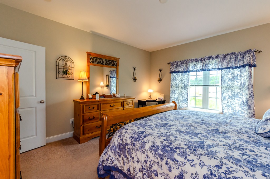 2 Thorn Hill Road, Unit 2 Hooksett, NH 03106 - Photo 18 of 27 a bedroom with a bed and a dresser next to a window