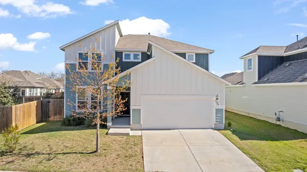 a view of a white house next to a yard