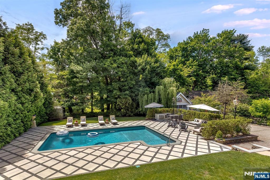 380 Ridgewood Avenue Glen Ridge, NJ 07028 - Photo 47 of 50 a view of yard with swimming pool outdoor seating and trees in the background