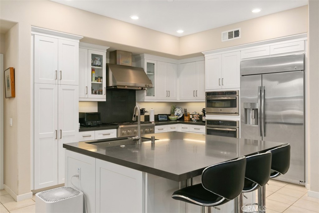 a kitchen with stainless steel appliances granite countertop a sink refrigerator and cabinets