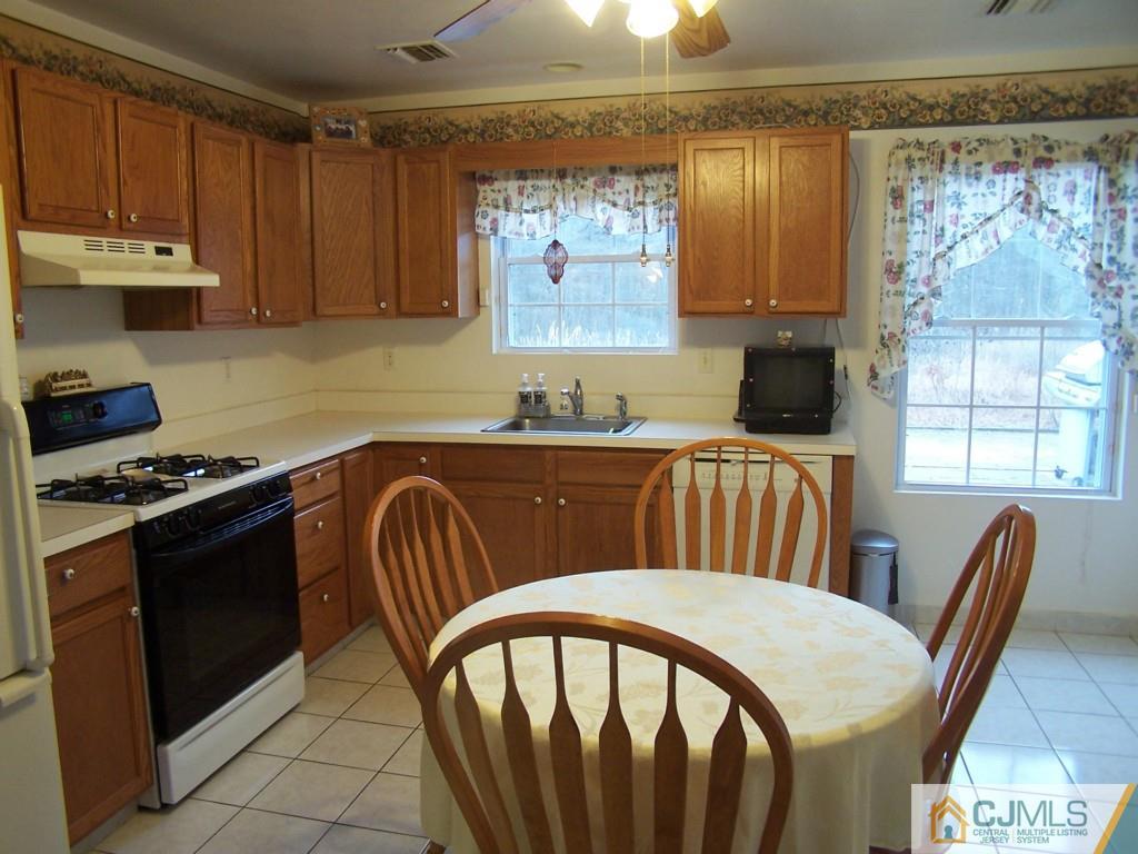 9 Westley Road Old Bridge, NJ 08857 - Photo 8 of 16 a kitchen with stainless steel appliances granite countertop a stove a sink dishwasher and cabinets with wooden floor