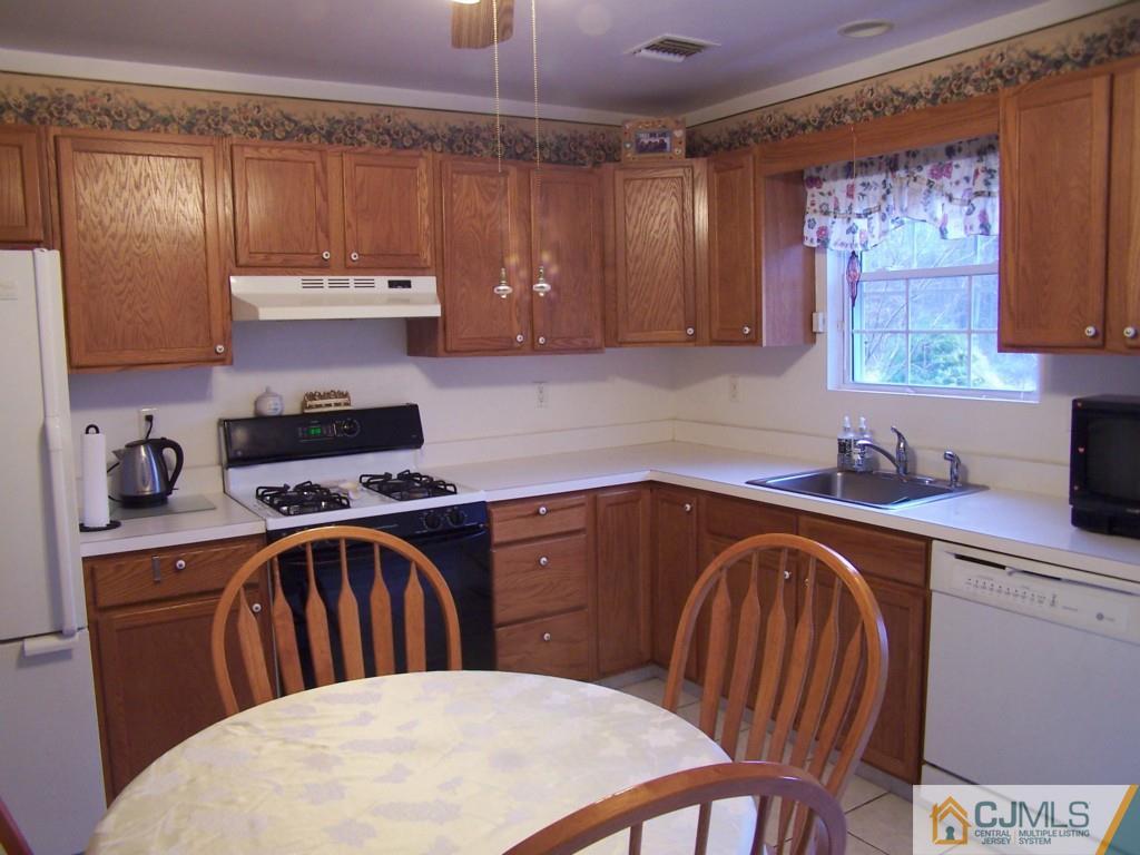 9 Westley Road Old Bridge, NJ 08857 - Photo 9 of 16 a kitchen with stainless steel appliances granite countertop a sink a stove a refrigerator cabinets and dining table