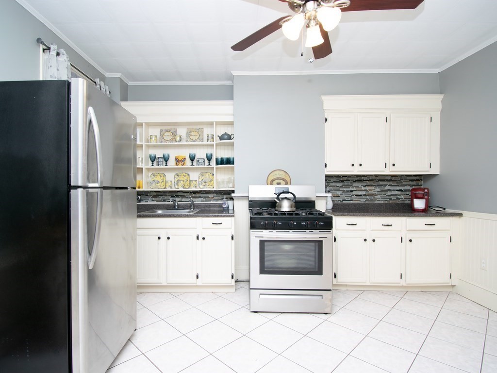 100 Elm Street Boston, MA 02129 - Photo 6 of 18 a kitchen with stainless steel appliances a stove a refrigerator and white cabinets