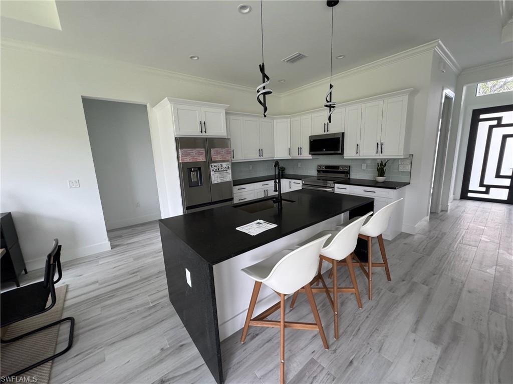 308 Golden Gate Boulevard East Naples, FL 34117 - Photo 12 of 29 a kitchen with granite countertop a sink stove and wooden floor
