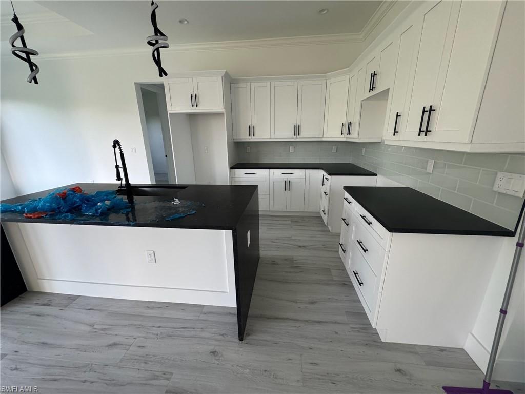 308 Golden Gate Boulevard East Naples, FL 34117 - Photo 15 of 29 a large white kitchen with stainless steel appliances a stove a refrigerator and white cabinets