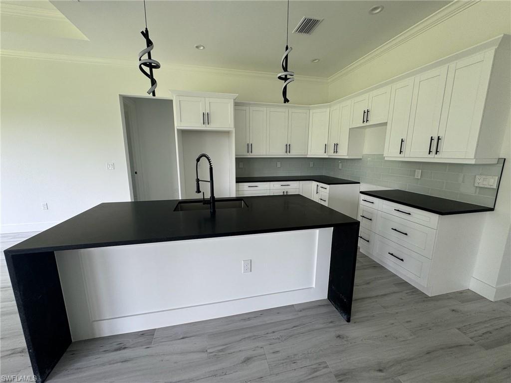 308 Golden Gate Boulevard East Naples, FL 34117 - Photo 16 of 29 a kitchen with a sink a stove and cabinets