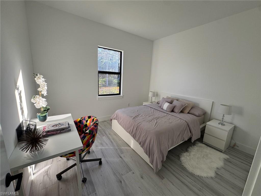 308 Golden Gate Boulevard East Naples, FL 34117 - Photo 19 of 29 a bedroom with a bed and a chandelier