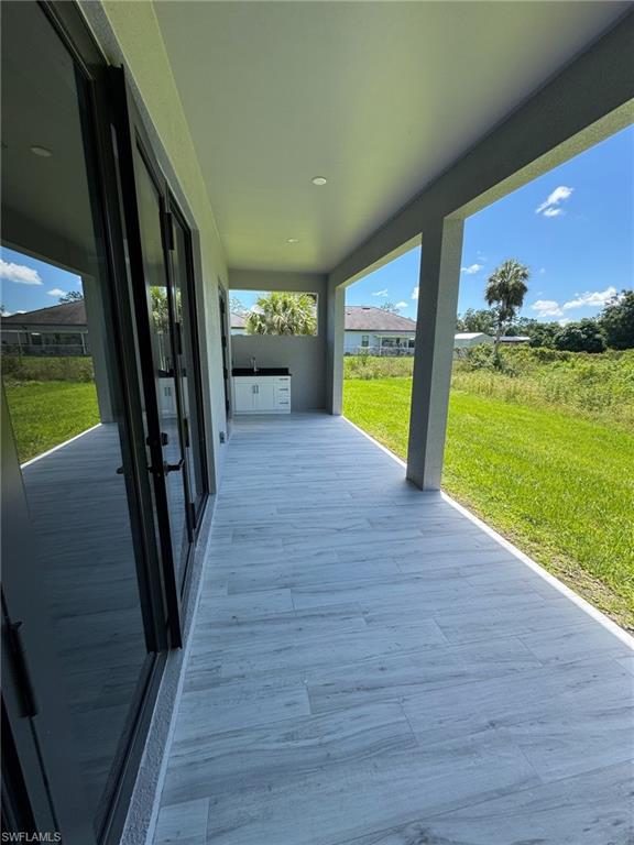 308 Golden Gate Boulevard East Naples, FL 34117 - Photo 25 of 29 a view of a living room and floor to ceiling window with wooden floor