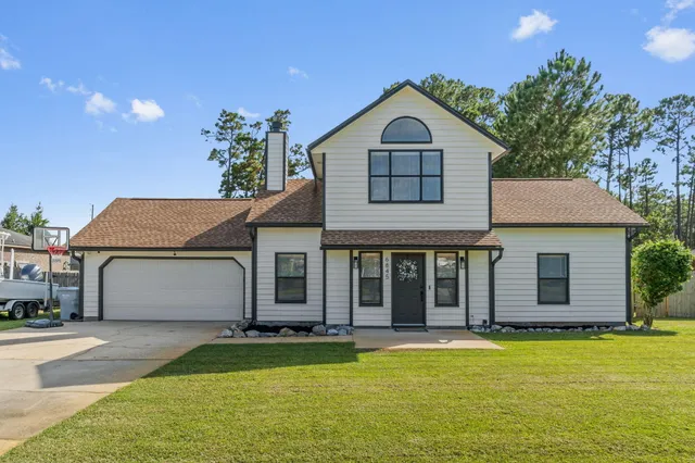 a front view of a house with a garden and yard