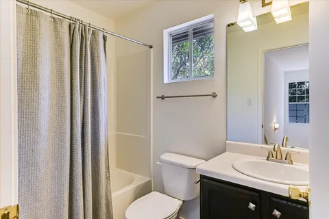 a bathroom with a sink a toilet a mirror and shower