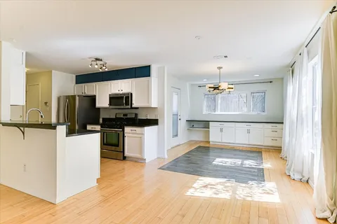 a view of a kitchen with wooden floor and electronic appliances