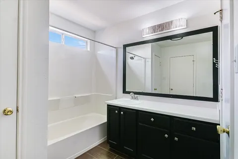a bathroom with a bathtub a sink a vanity and a mirror