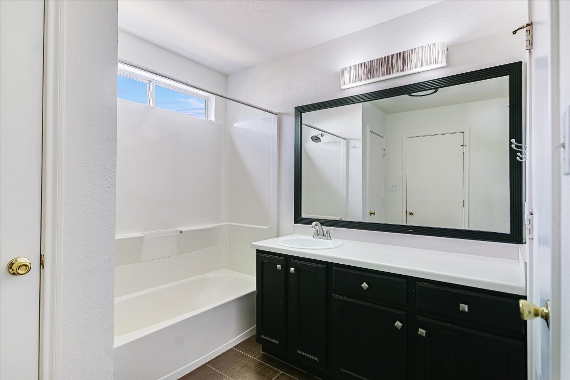 1193 Curve Street Austin, TX 78702 - Photo 10 of 18 a bathroom with a bathtub a sink a vanity and a mirror