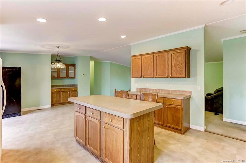 4737 White Store Road Wingate, NC 28174 - Photo 11 of 36 a hall with kitchen island a sink granite counter tops and a stove