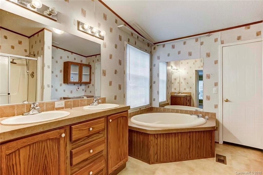 4737 White Store Road Wingate, NC 28174 - Photo 20 of 36 a bathroom with a tub a sink double vanity and a mirror
