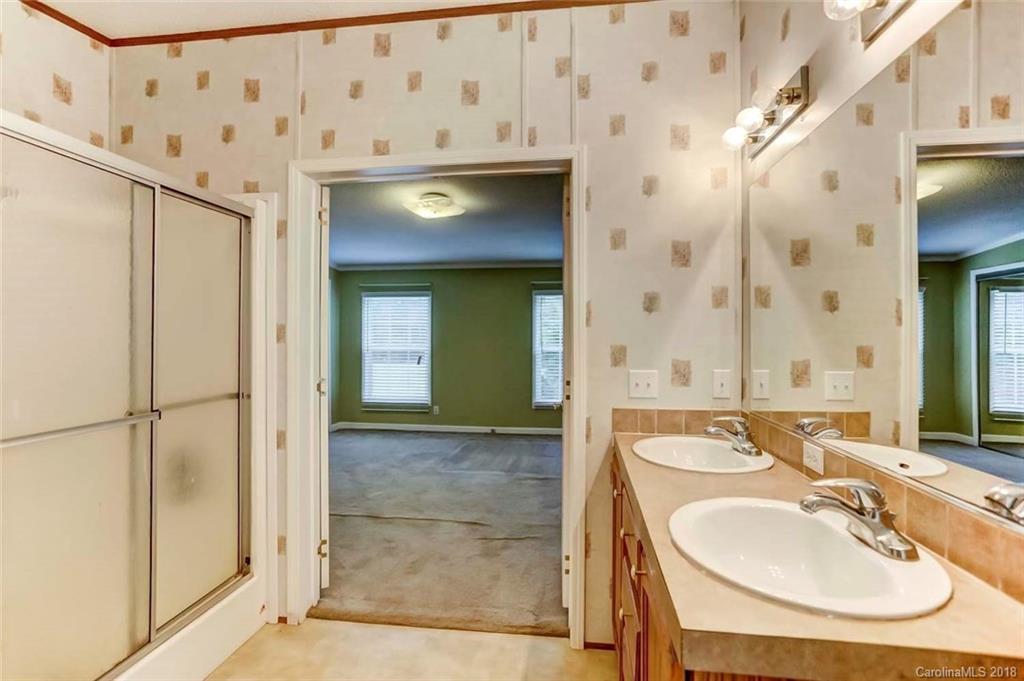 4737 White Store Road Wingate, NC 28174 - Photo 21 of 36 a bathroom with a sink a mirror and a shower