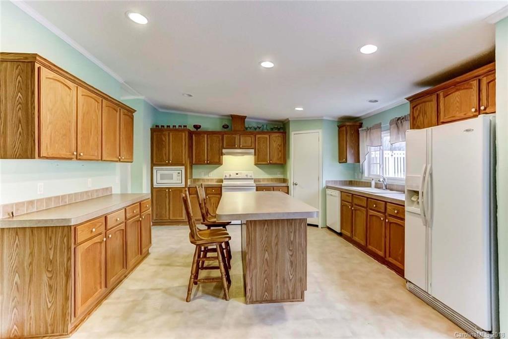 4737 White Store Road Wingate, NC 28174 - Photo 7 of 36 a kitchen with refrigerator a stove a sink and cabinets