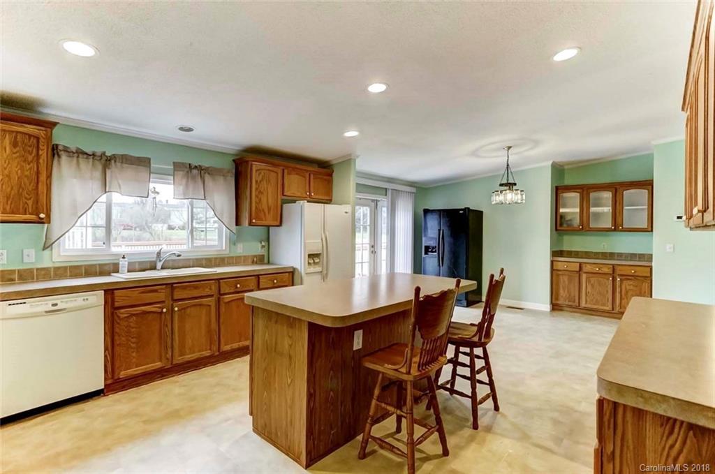 4737 White Store Road Wingate, NC 28174 - Photo 8 of 36 a kitchen with stainless steel appliances granite countertop a sink a stove a dining table and chairs
