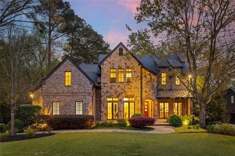 a front view of house with yard and trees in the background