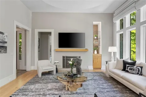 a kitchen with a stove a sink a counter top space and living room view