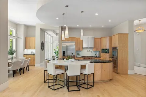 a dining room with stainless steel appliances kitchen island granite countertop a table and chairs
