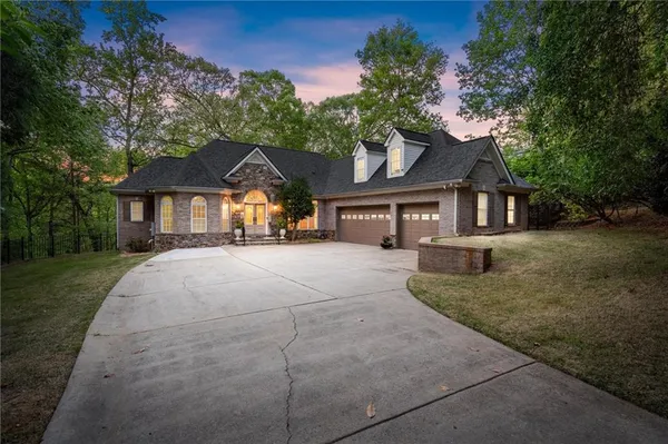 a front view of a house with a yard and trees