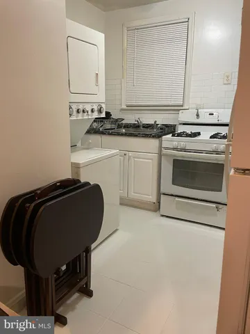 a kitchen with a stove and white cabinet