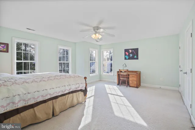 a spacious bedroom with a bed and a chandelier