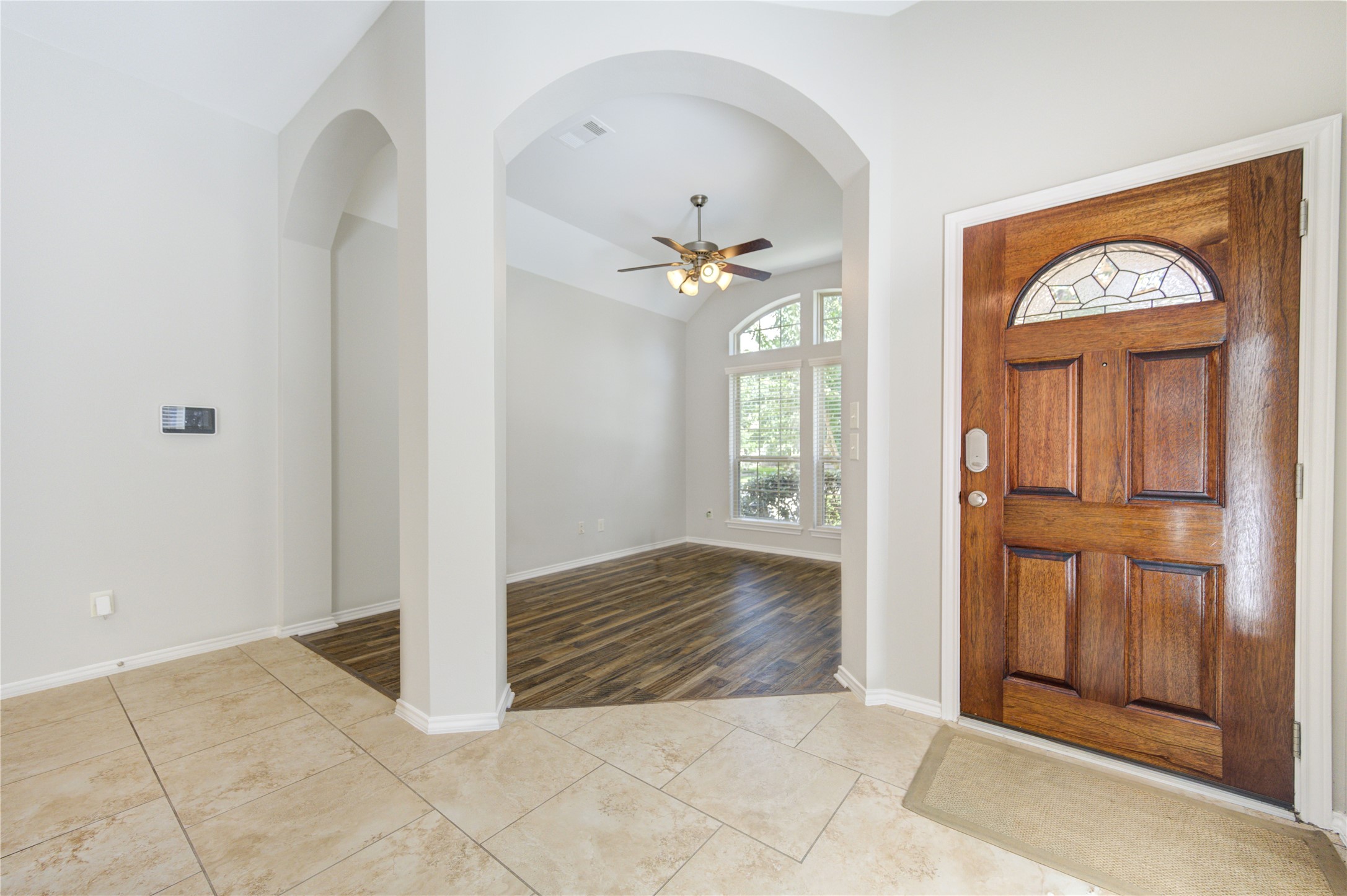 27407 Gatlin Lane Spring, TX 77386 - Photo 8 of 35 Step inside to a bright and welcoming foyer where soaring ceilings, elegant archways, and warm wood-look flooring create an immediate sense of openness. The thoughtfully designed entry offers a graceful transition into the home's living spaces, setting the tone for the impeccable condition and inviting atmosphere found throughout.