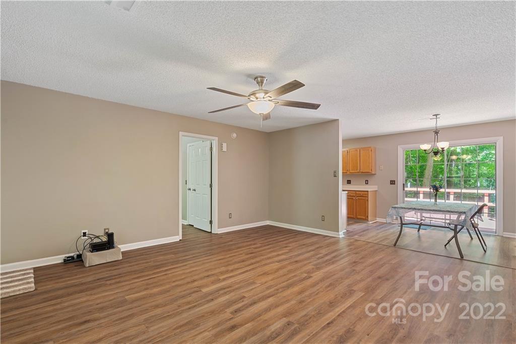 225 Creek View Road Mooresville, NC 28117 - Photo 3 of 18 an empty room with wooden floor and a ceiling fan