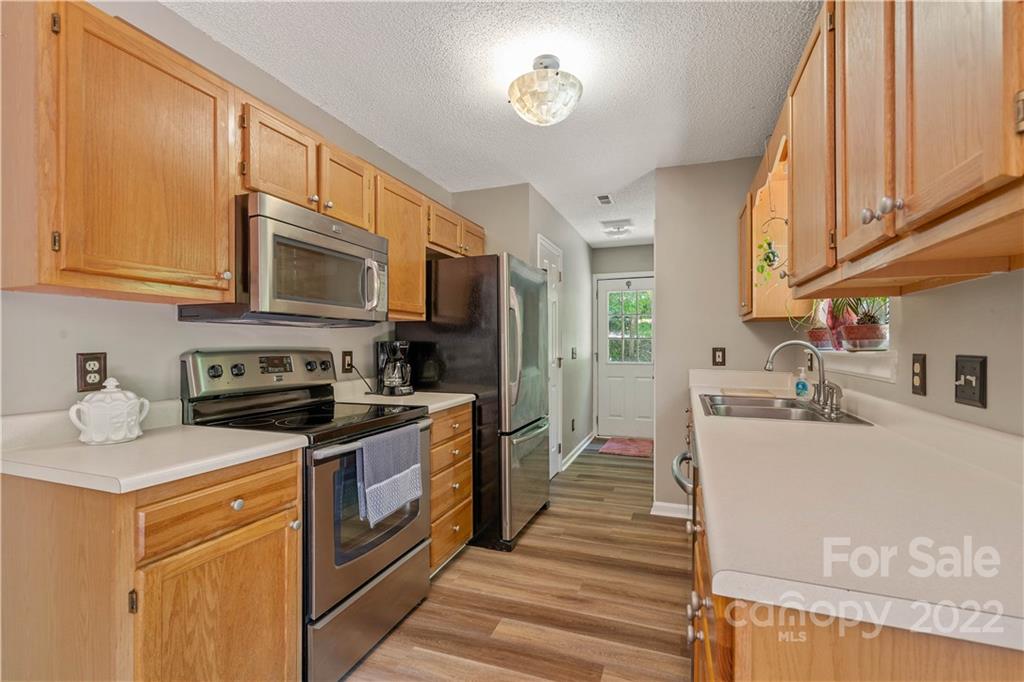 225 Creek View Road Mooresville, NC 28117 - Photo 6 of 18 a kitchen with stainless steel appliances granite countertop a sink stove microwave refrigerator and cabinets